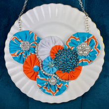 Load image into Gallery viewer, Aqua and Orange Flower Bomb Necklace with Turquoise and Pearl Pins on a white plate
